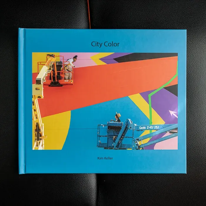 A top down photo of Kim Keller's photo book City Color. The front cover features a colorful geometric background.